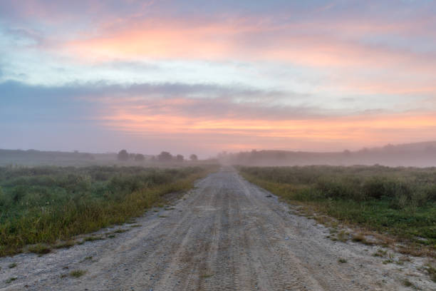 The sun's rise colors the sky above an off-road trail.