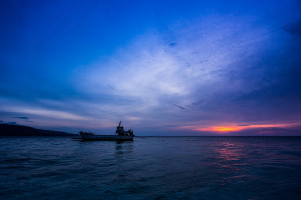 a ship on the sea in the sunrise