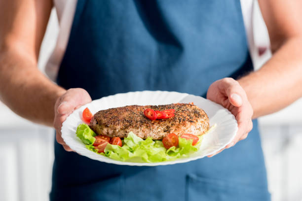 istock partial view of male hands with cooked meat on plate 1067912512