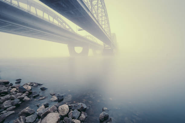istock Two parallel bridges over foggy river. Long exposure shot. 1067915442