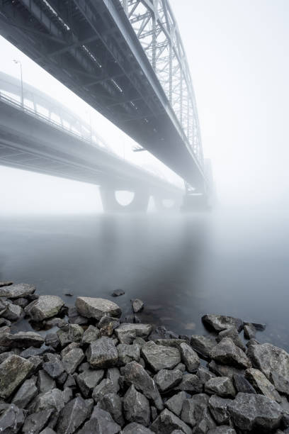 istock Two parallel arch bridges over foggy river. Long exposure shot. 1067915458