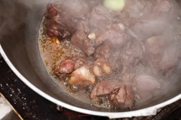 Photo of Lamb with onion boiling in a cauldron