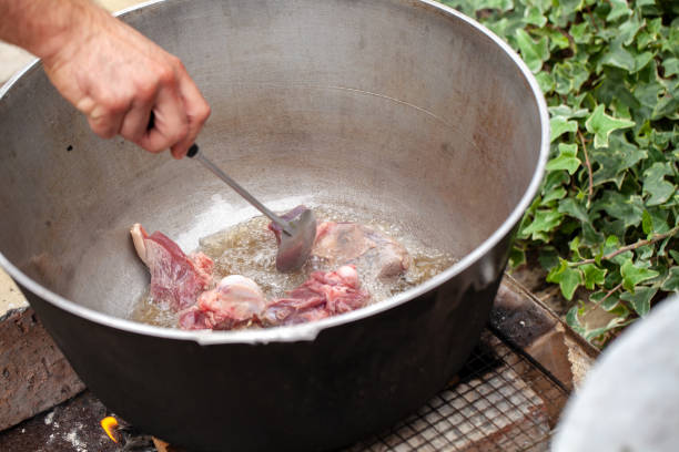 istock Cook mixes lamb pieces in cauldron 1067920814