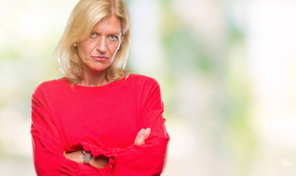 istock Middle age blonde woman over isolated background skeptic and nervous, disapproving expression on face with crossed arms. Negative person. 1067921480