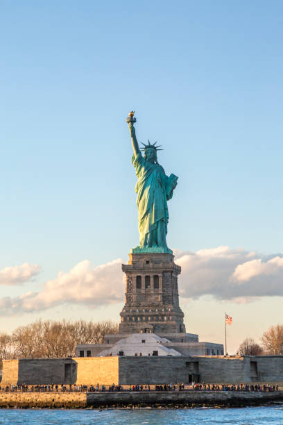 statua della libertà verticale durante il tramonto a new york city, ny, usa - dusk people manhattan new york city foto e immagini stock