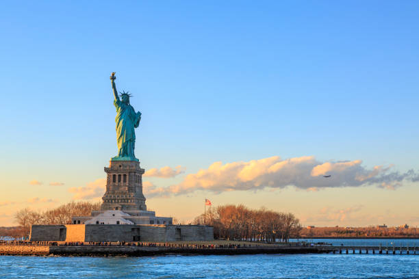 ニューヨーク、ニューヨーク、アメリカ合衆国の日没時に水平方向の自由の女神 - crown liberty statue ストックフォトと画像