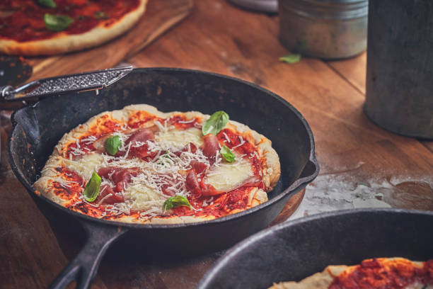 istock Preparing Pizza with Mozzarella and Ham in a Pan 1067939252