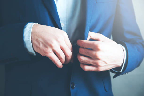 istock young business man holding suit's button 1067941106