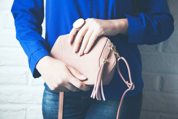 istock woman hand bag in brick wall background 1067941226