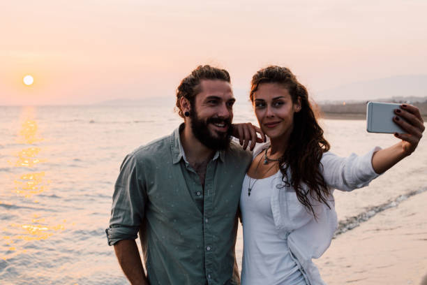 istock Happy couple making a selfie at the beach 1067949872