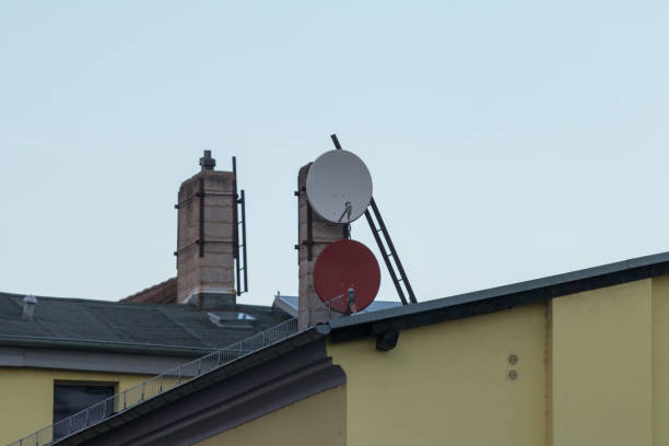 istock Satellite dishes on house roof 1067958120