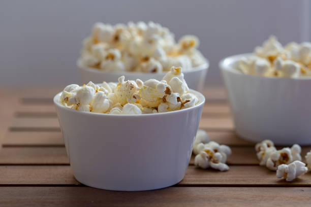 istock popcorn and popcorn grains on white plate on wooden background 1067960598