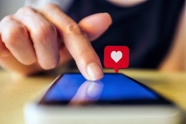istock Young woman using smart phone with social media symbols 1067965362