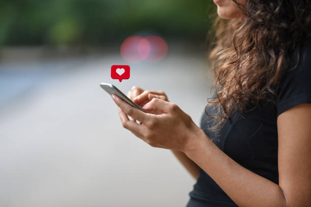 istock Young woman using smart phone with social media symbols 1067965978