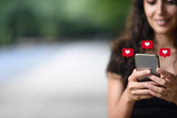 istock Young woman using smart phone with social media symbols 1067967894
