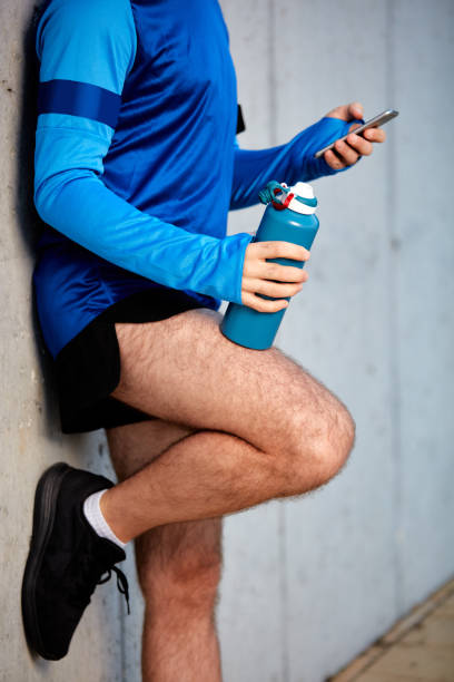 istock Close up of male runner leaning on wall. 1067970176
