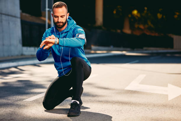 istock Man kneeling and checking heart beat on smart watch. 1067974448