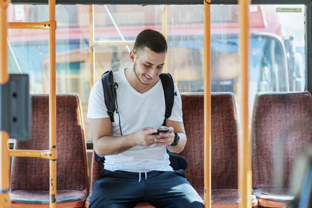 istock Young Man in the Bus with Smart Phone 1067975150