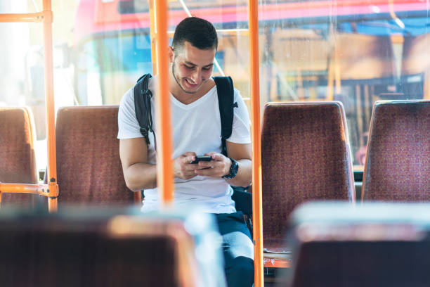 istock Young Man in the Bus with Smart Phone 1067975164