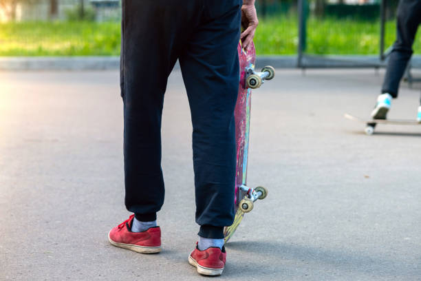 istock Skater boy with battered and scruffy skateboard. Trick preparation 1067988528