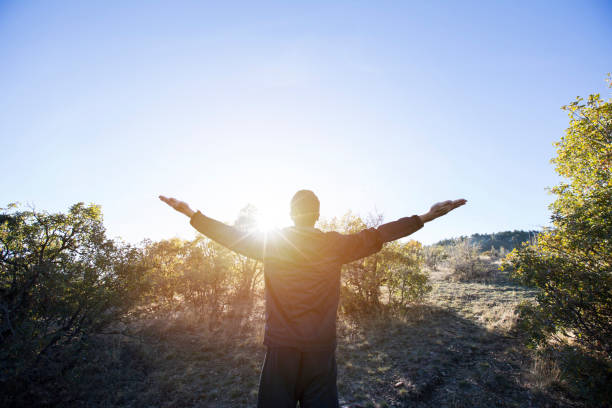 istock man enjoying summer outdoors at nature with sunlight. Freedom concept 1067993570