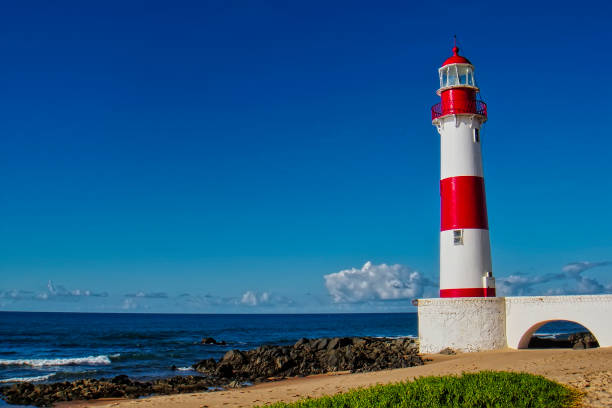 leuchtturm itapua strand mit blauem himmel, salvador, bahia, brasilien - sea sign direction beacon stock-fotos und bilder