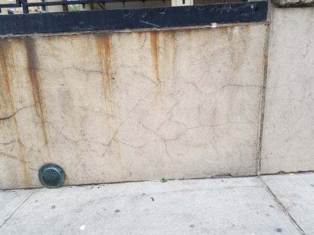 istock NYC surface - concrete retaining wall with drain at ground level 1068003304