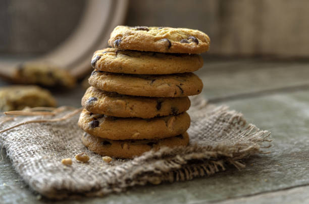 istock Stacked rounded chocolate cookies on natural wooden desk. 1068012722