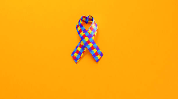 istock Heart Shaped Autism Awareness Ribbon On Yellow Background 1068015890