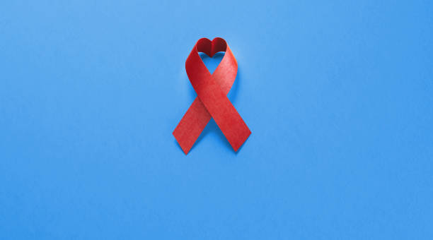 cinta del conocimiento del sida sobre fondo azul - aids awareness ribbon fotos fotografías e imágenes de stock