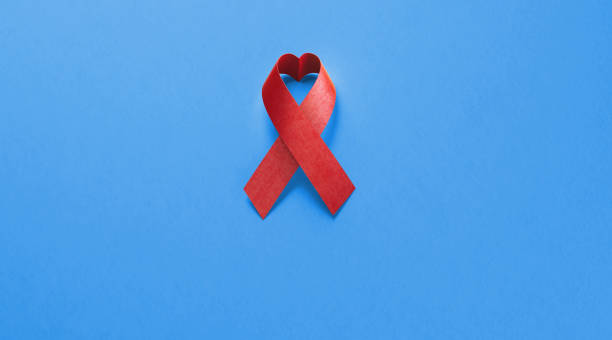 лента осведомленности о спиде на синем фоне - aids awareness ribbon фотографии стоковые фото и изображения