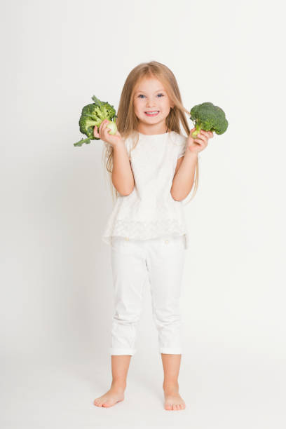 istock Happy child with vegetables broccoli
on a white background 1068019842