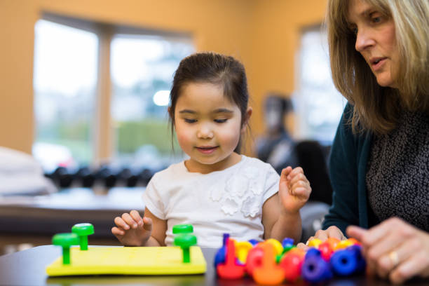 istock Occupational therapist works with a young ethnic girl 1068023744
