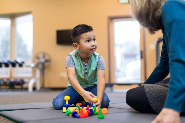 istock Occupational therapist works with a young ethnic boy 1068023758