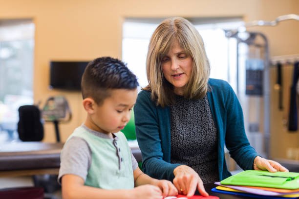 istock Occupational therapist works with a young ethnic boy 1068023780