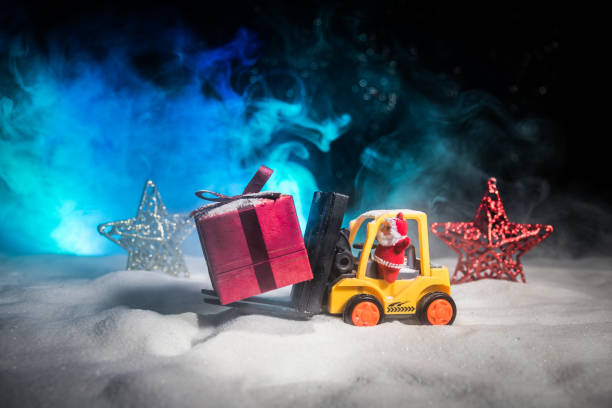 istock Miniature Gift Box by Forklift Machine on snow ,Determined Image for Christmas Holiday and Happy New Year Gift Celebration concept. 1068024068