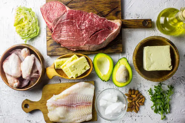 Keto diet concept. Ketogenic diet food. Balanced low-carb food background. Fish, meat, cheese, nuts on a white background. Healthy balanced food with high content of healthy fats. Diet for the heart and blood vessels.