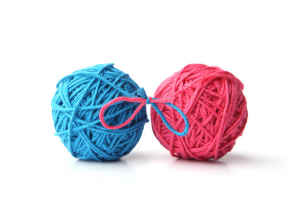 istock Two pink and blue cotton thread balls tied in bow isolated on white background. 1068031264
