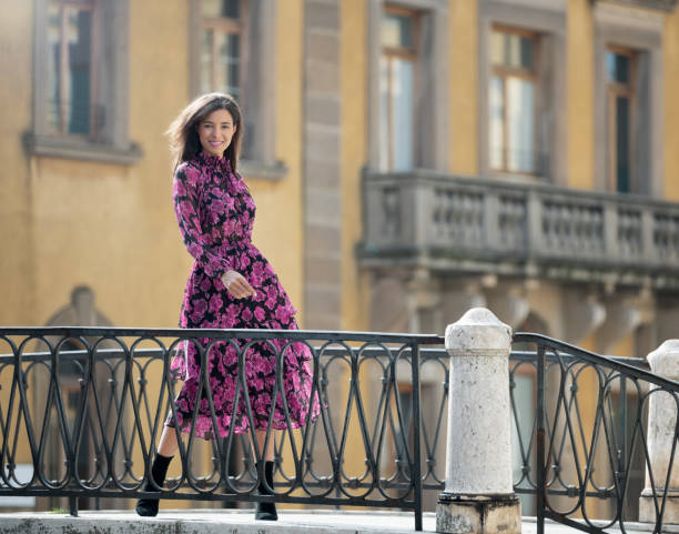 modelo com um sorriso sincero em uma ponte em veneza, itália - floral dress - fotografias e filmes do acervo