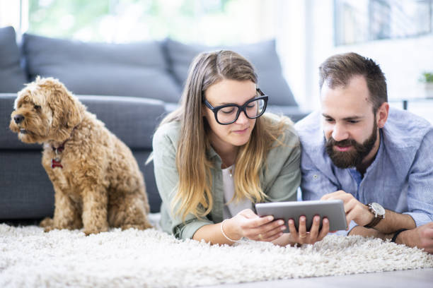 istock Couple laying on a rug looking at a tablet 1068037712