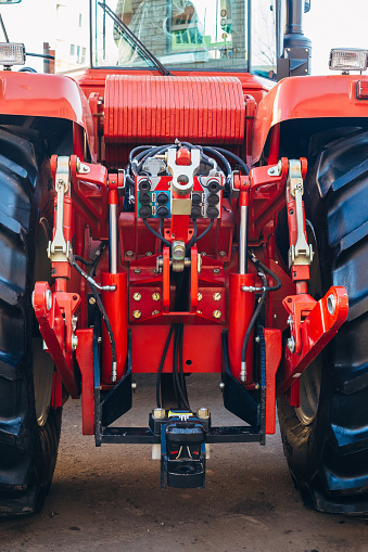 Rear view of modern agricultural tractor. Hydraulic hitch. Lifting frame. Rear mechanism for attaching trailed equipment.