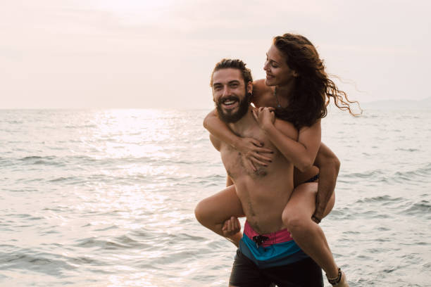 istock Smiling man with woman sitting on his back 1068044336