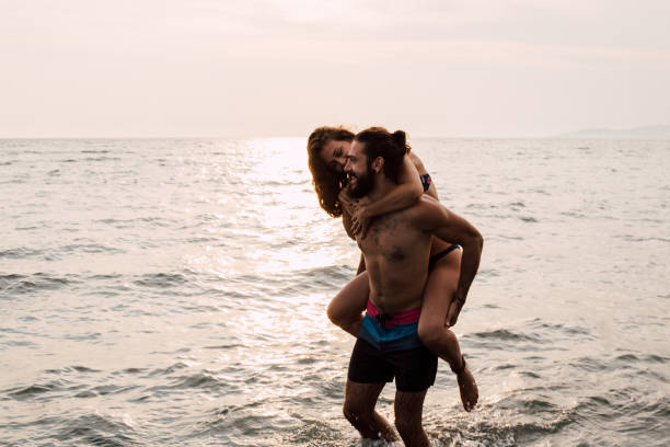 istock Man carrying girlfriend at the beach 1068044606