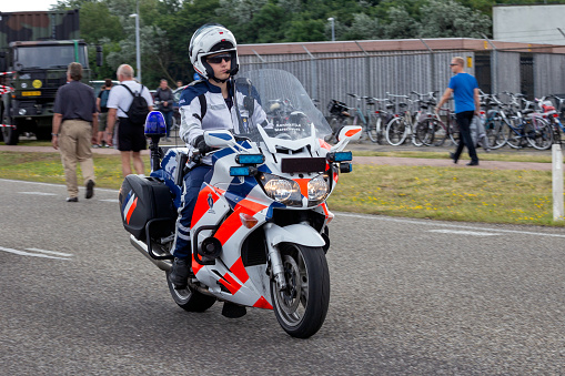 Den Helder, The Netherlands - Jul 7, 2012: Dutch military police (Marechaussee) officers patrolling on his motorbike in the street.