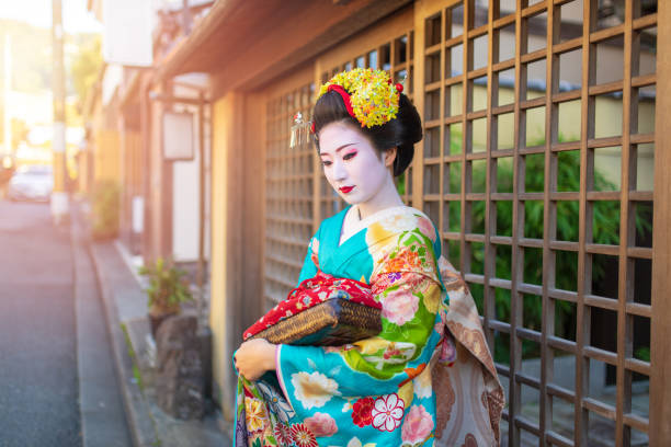 maiko apprentice geisha in piedi di fronte all'ingresso della casa - stage makeup make up women body paint foto e immagini stock