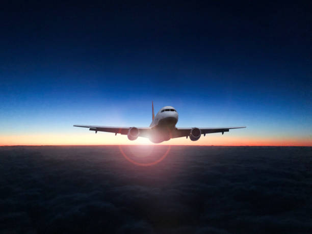 istock The silhouette of a passenger plane flying in sunset. 1068050030