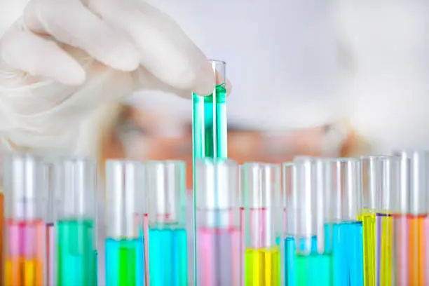 Scientist injecting liquid from syringe into fruits and vegetables.Genetically modified organism - apple and laboratory glassware.