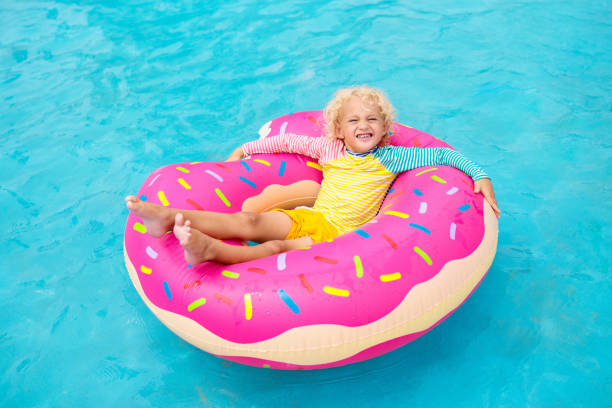 criança na piscina na boia de donut - 15830 - fotografias e filmes do acervo