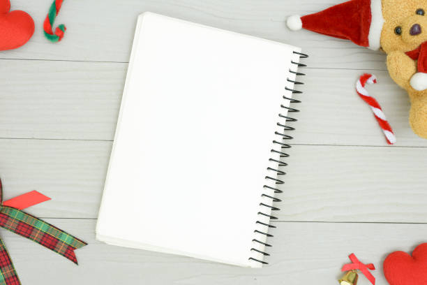 istock Christmas bear and white book with top view and copy space on the white wooden table. Christmas holiday concept. 1068080962