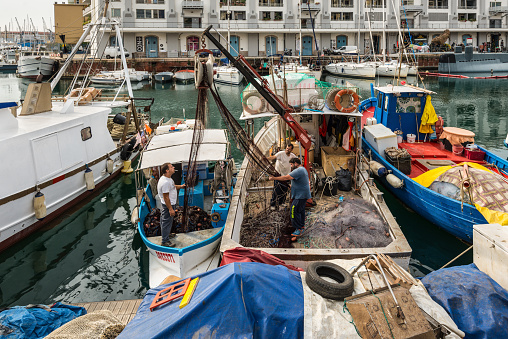 Genoa, Italy - October 28, 2017: Fishermen arranges their fishing net in Genoa (Genova), Liguria, Mediterranean coast, Italy.